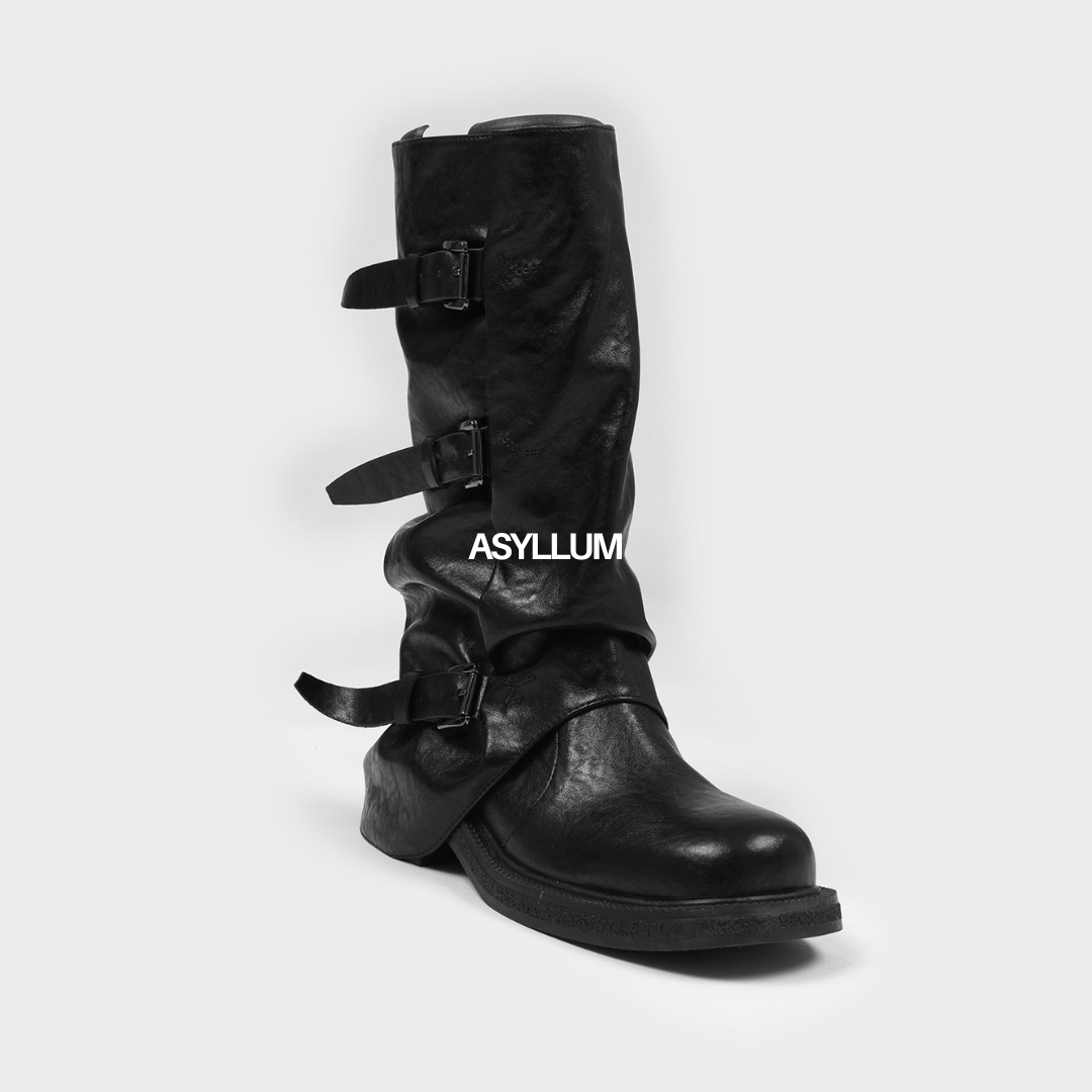 Black leather boot with buckles on a white background, featuring the brand 'ASYLUM'.